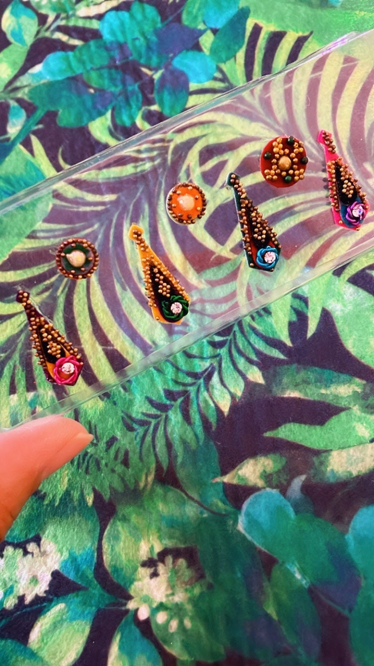 Handmade colorful marigold Jungle Bindis or nail art with gold beads and velvet face and body stickers